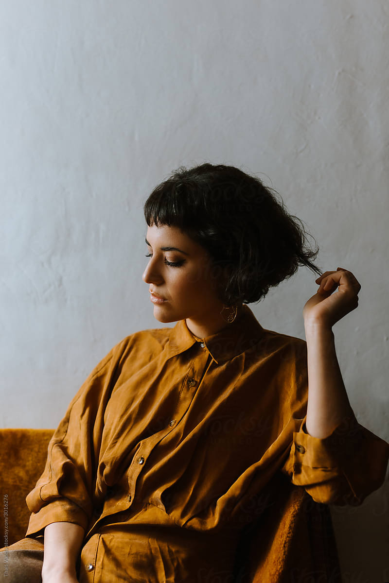 A woman with eyes lowered, resting in a calm moment.