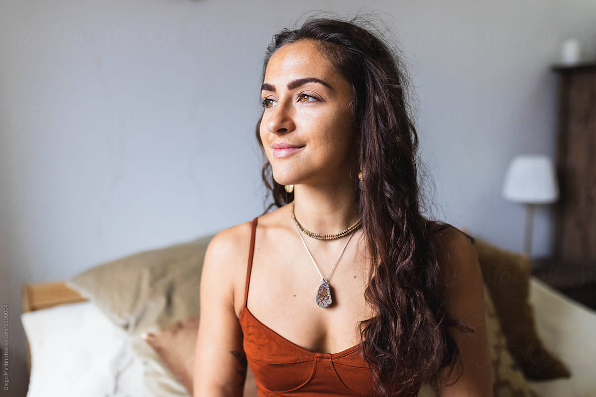 A woman sitting quietly in warm light, looking inward.